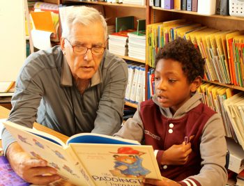 Tutor John Candelaria reading with student Tutor John Candelaria reading with student
